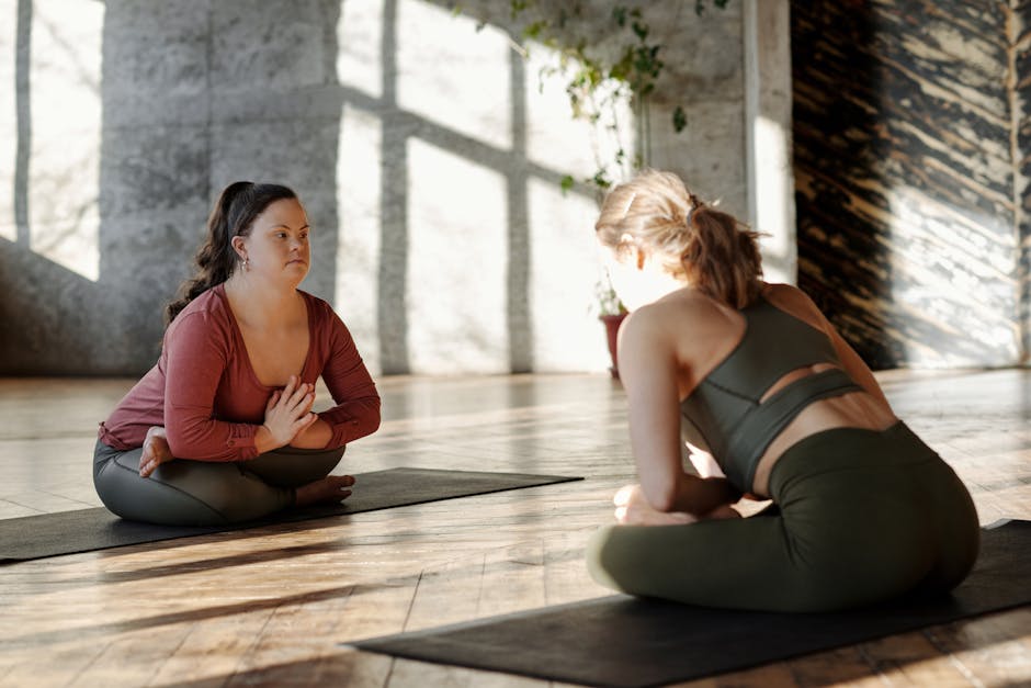Two women practicing yoga together in a sunlit studio