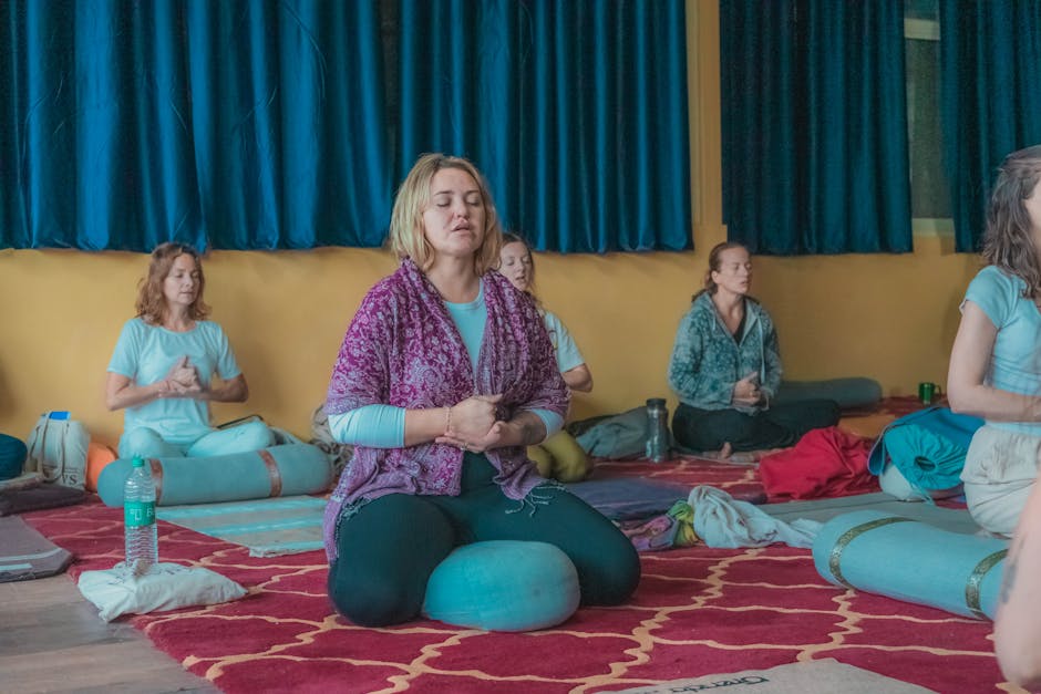 Group of women meditating together in a peaceful indoor setting