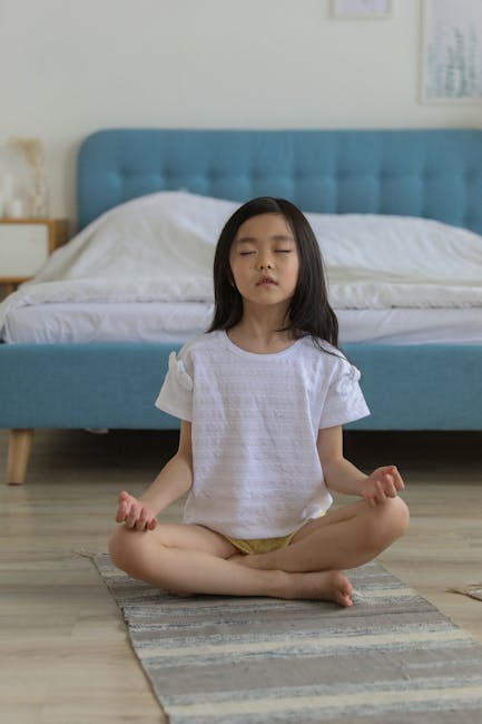 Young girl practicing meditation on a yoga mat at home