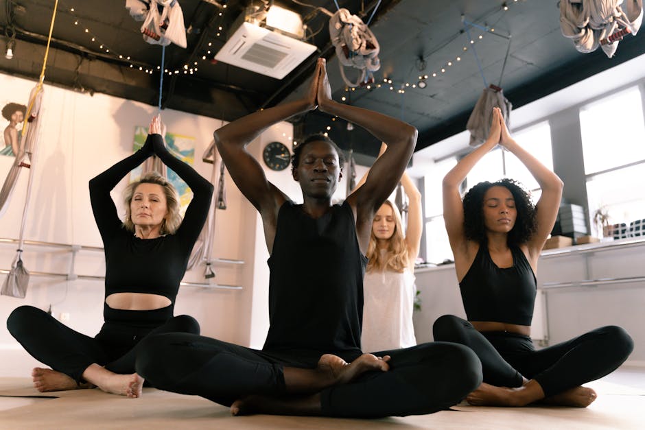 Group of diverse people in a yoga class raising hands together